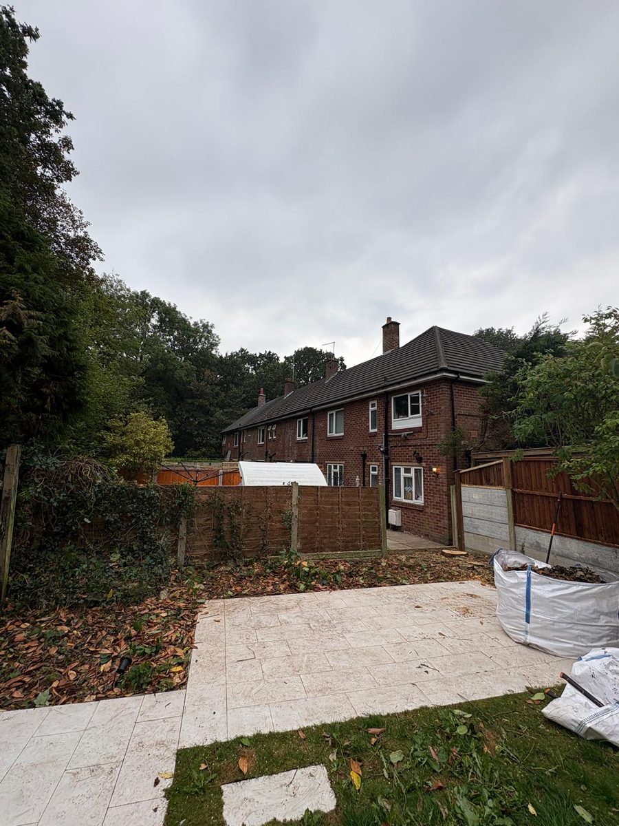 The same garden cleared to the fence, the paving swept, bags of cuttings by the fence